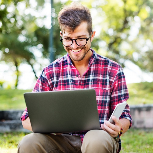 young-man-smartphone-browsing-laptop-concept-2021-08-26-23-58-12-utc-1